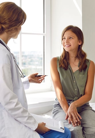 A happy girl being consulted by her doctor